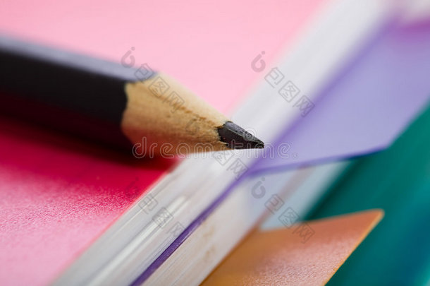 粉色笔记本和黑色铅笔