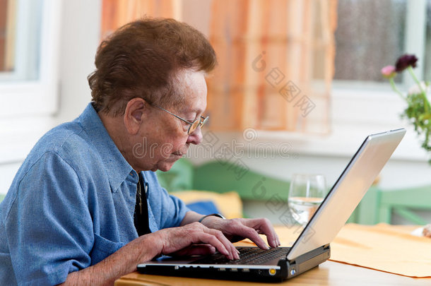 活跃的老年人，闲暇时带着笔记本电脑