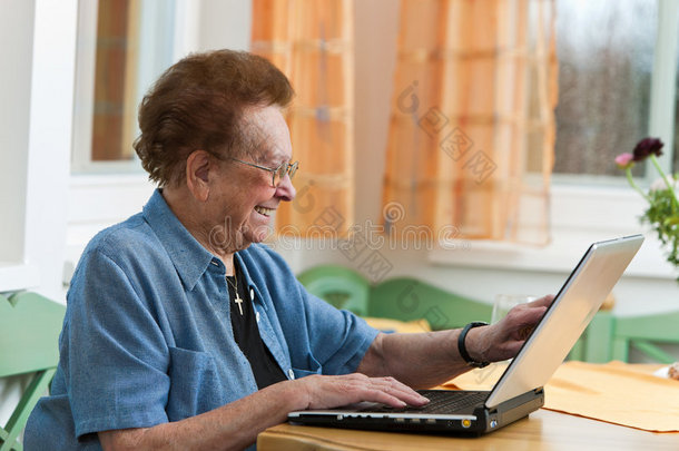 活跃的老年人，闲暇时带着笔记本电脑