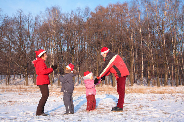 戴着红帽子的父母和孩子在冬天玩耍