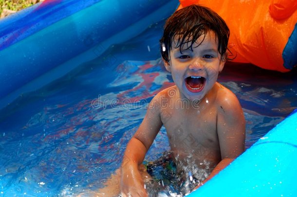 小男孩笑着在游泳池里<strong>溅水</strong>