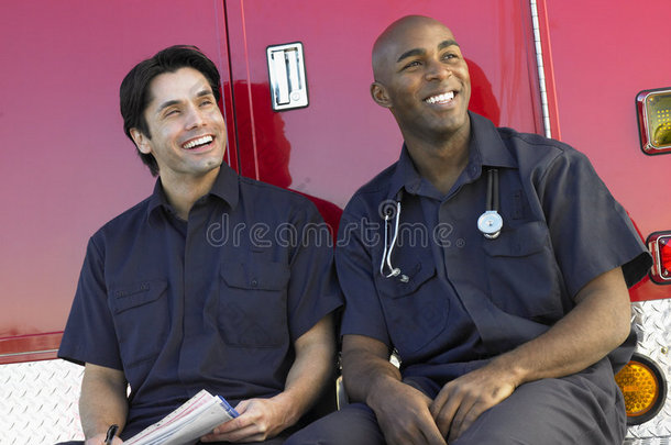 两名医护人员坐在救护车旁