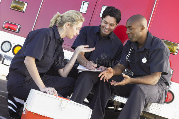 三名医护人员在救护车旁聊天