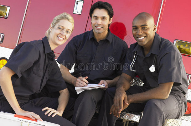 三名医护人员在救护车旁聊天