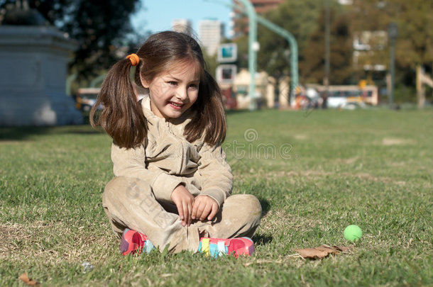 公园里坐在草地上的小女孩