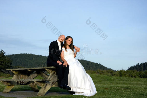 新娘和新郎坐在野餐桌上