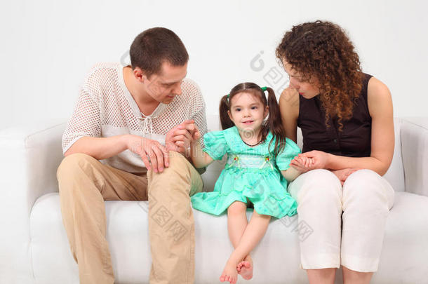 白色真皮沙发上的父母和女儿