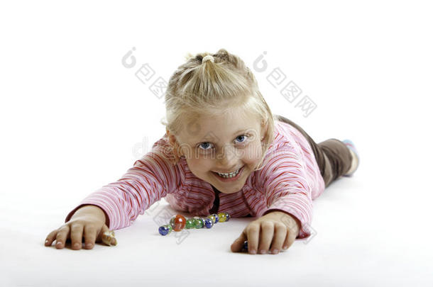 快乐的孩子躺在地板上弹珠