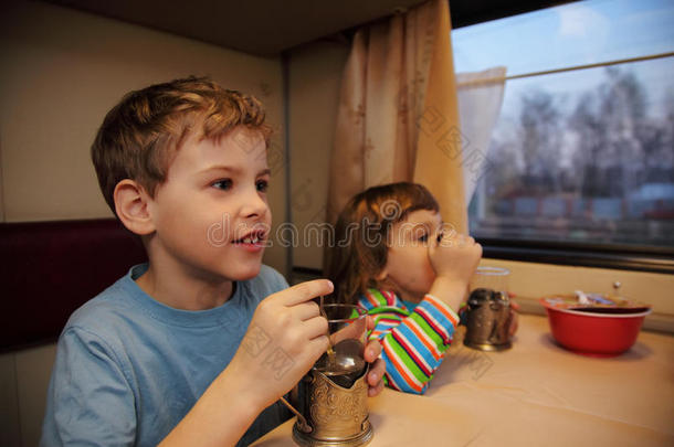 两个孩子在火车车厢喝茶