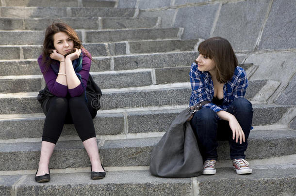 两个十几岁的女孩坐在楼梯上