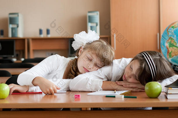 两个过度劳累的未成年女学生正在睡觉