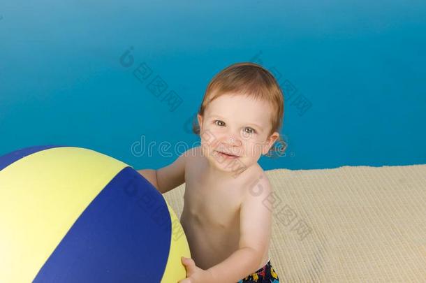 带沙滩球的游泳池男孩