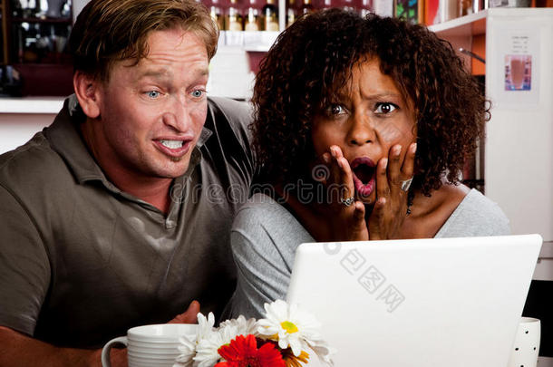 一对混血夫妇在咖啡厅用笔记本电脑