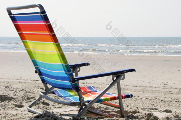 沙滩上彩虹色的沙滩椅，大海