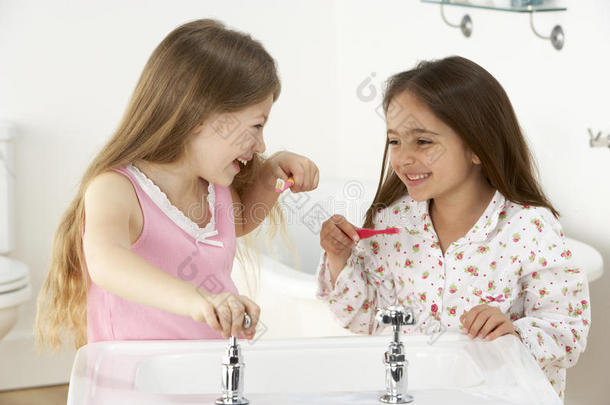 两个小女孩在水槽里刷牙