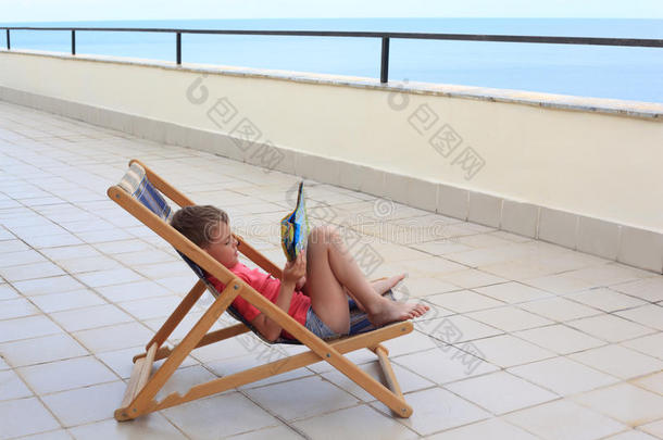 男孩在阳台的休息室看书