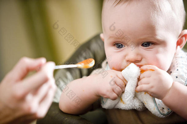 可爱的宝宝用勺子吃固体食物