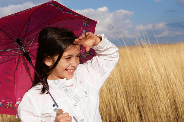 田野里带着雨伞的小女孩