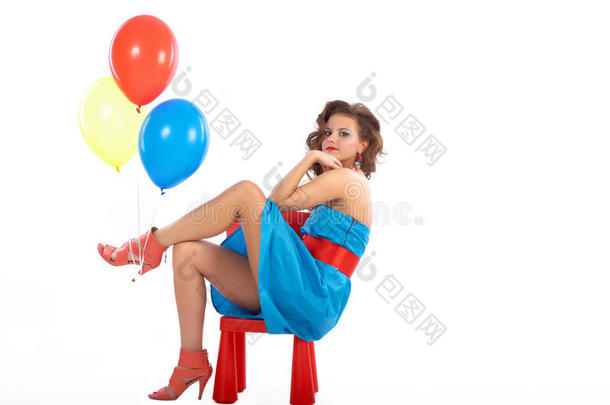坐在红色小椅子上<strong>拿</strong>着<strong>气球</strong>的女人