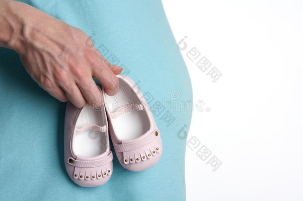 怀着孕肚子，双手抱着婴儿鞋