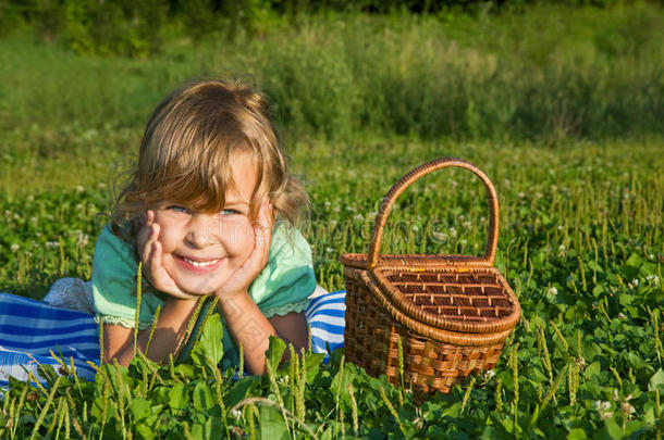 草地上提着篮子的漂亮小女孩