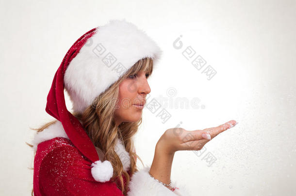 年轻的圣诞妇女在吹雪