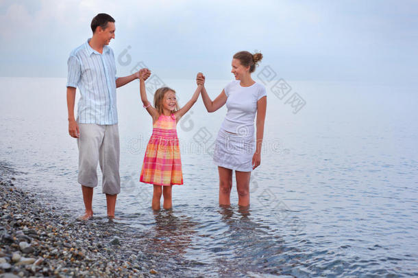 幸福的一家人<strong>手牵手</strong>在沙滩上<strong>散步</strong>