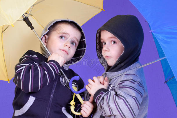 <strong>双胞胎兄弟</strong>在雨伞下玩得很开心