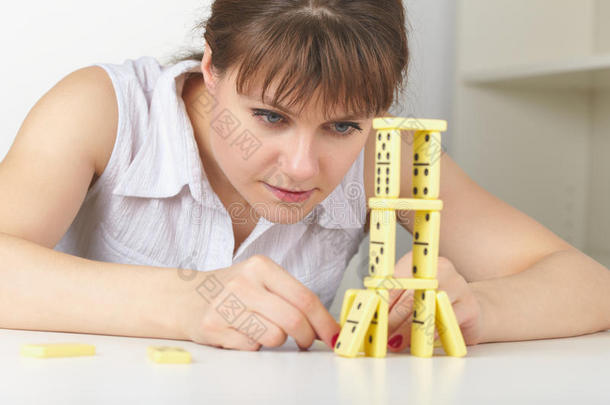 年轻女子<strong>精准</strong>打造多米诺骨牌塔