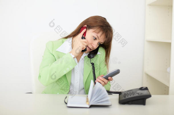 女秘书用几部电话讲话