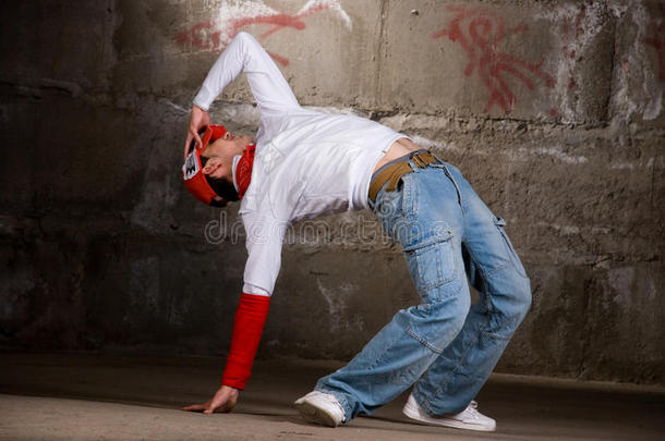 灰墙上现代风格的嘻哈男孩舞蹈