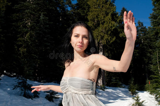 在雪地里摆姿势的穿着<strong>飘逸</strong>连衣裙的美女