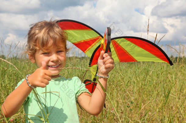 小女孩在草地上用ok的手势放风筝
