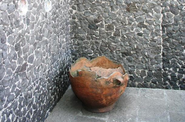 靠着石墙的古代陶罐
