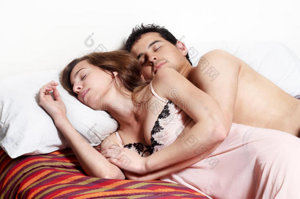 一对年轻夫妇睡在床上。