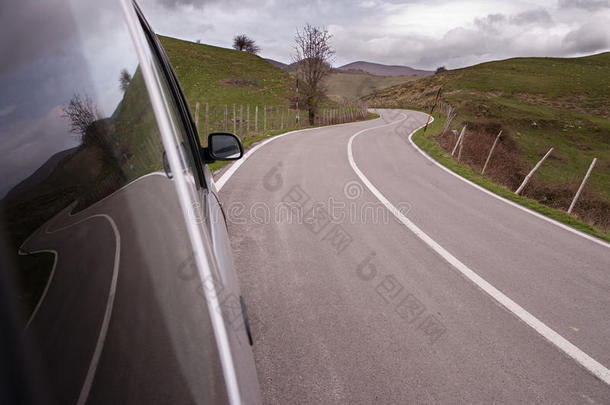 蜿蜒的道路反射在<strong>汽车</strong>的侧玻璃上