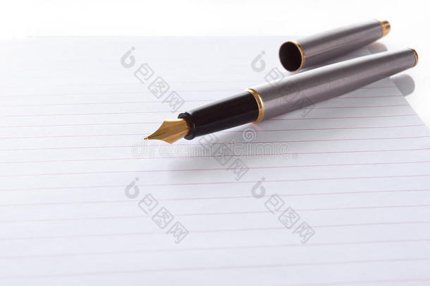 用螺旋装订的便笺把钢笔放在纸上