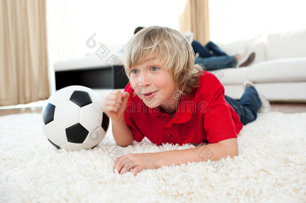 躺在地板上看<strong>足球赛</strong>的男孩
