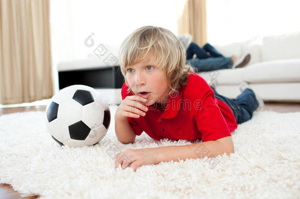 躺在地板上<strong>看足球</strong>赛的男孩
