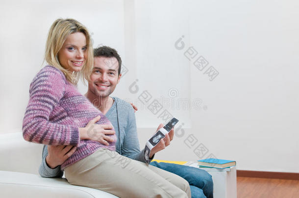 微笑的孕妇夫妇手持超声波扫描