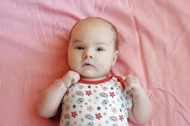 四个月大的婴儿躺在粉红色的毯子上