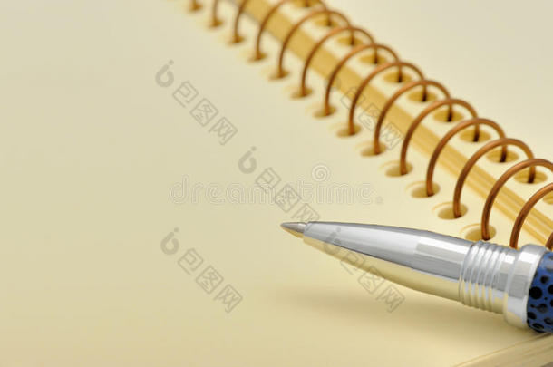 笔和笔记本呈螺旋形，上面有一张黄色的纸