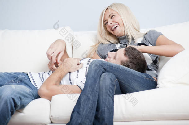 一对<strong>恩爱</strong>的夫妇在沙发上欢笑和放松