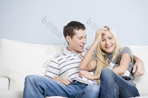 一对恩爱的夫妇在沙发上欢笑和放松