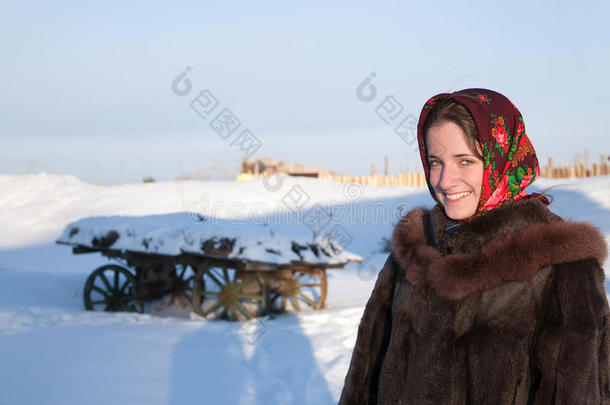穿着毛皮大衣的女孩对抗冬天的乡村景观