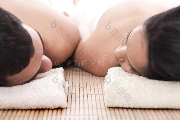 年轻男女躺在毛巾上泡温泉