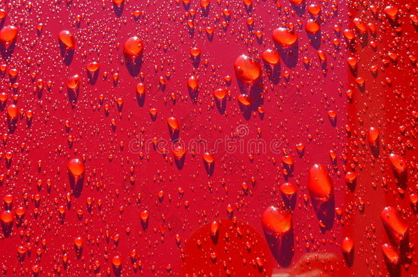 刚打蜡的红色汽车上有水滴