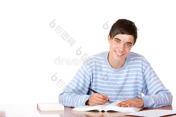 年轻快乐帅气男生在课桌上学习