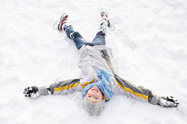 男孩躺在地上做雪天使