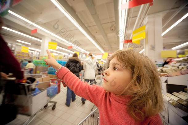 小女孩坐在超市的购物车里